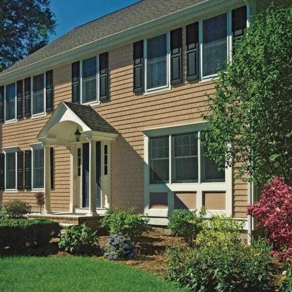 Light brown CertainTeed vinyl siding with big bushes